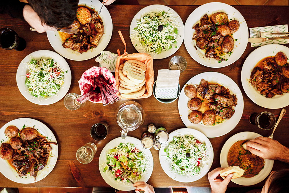 写真：いろんな料理が並んだテーブルを囲んでいる様子を真上から見たところ
