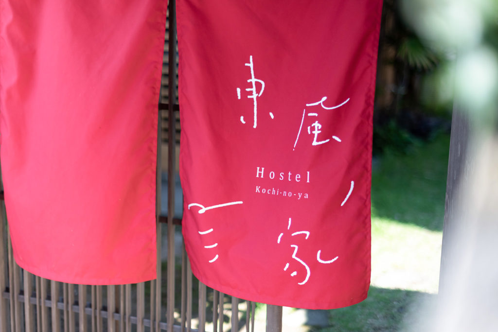 写真：鮮やかな赤いのれんに、東風ノ家のロゴが揺れている。