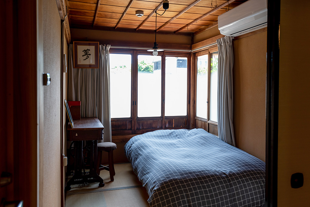 写真：部屋の全景。ベッドの枕元を囲むように窓がある。