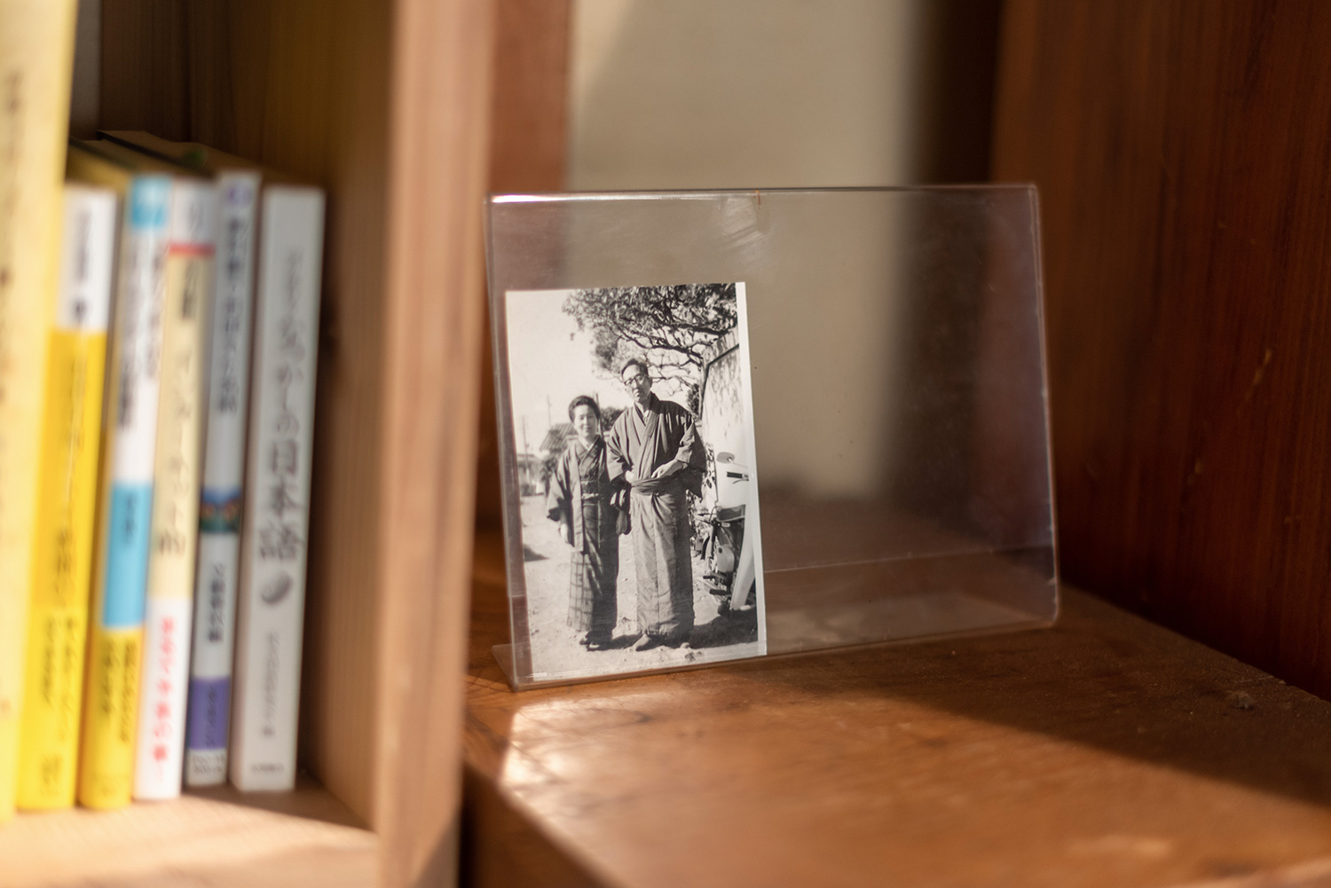 写真：着物を着た老夫婦のモノクロ写真が本棚の側に飾られている