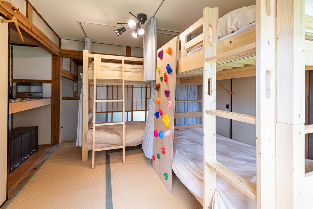 写真：木製の2段ベッドが2つある和室。押し入れの下はロッカースペース。