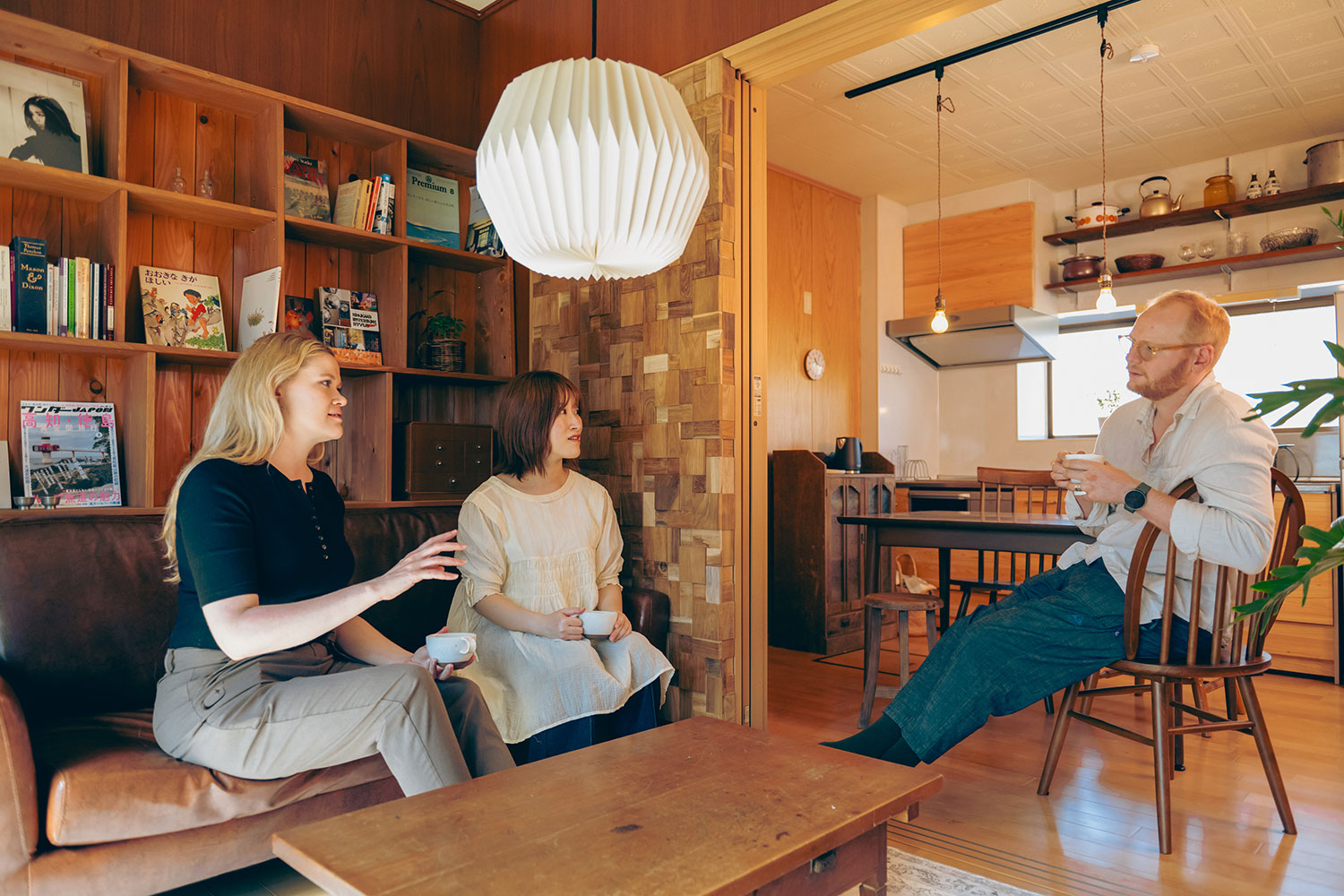 写真:リビングのソファで談笑する3人