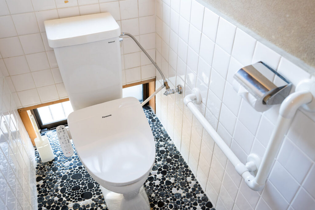 写真:真新しい洋式トイレ。床は玉石のタイル。