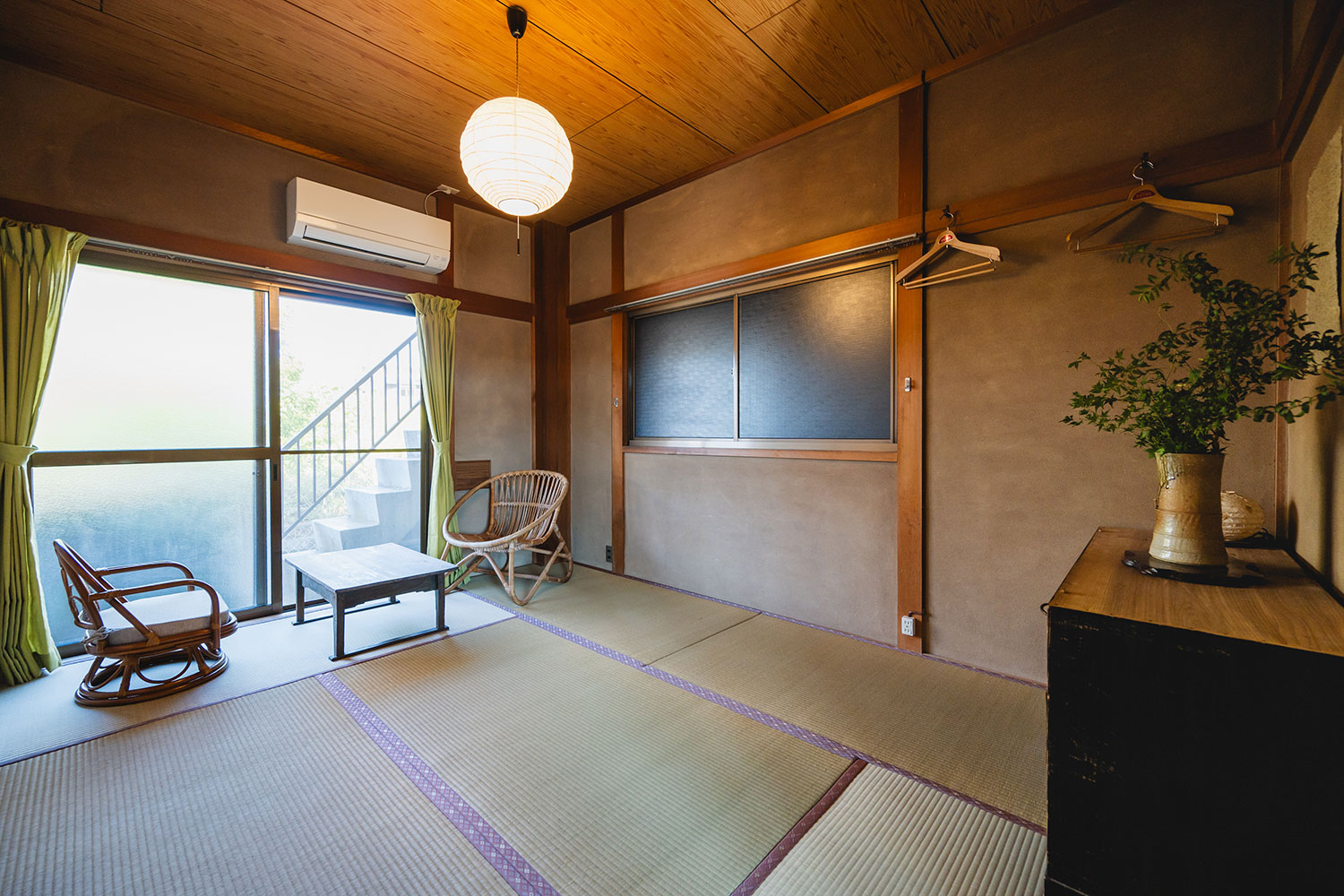 写真:畳の和室。窓際にローテーブルと2脚の椅子があります。