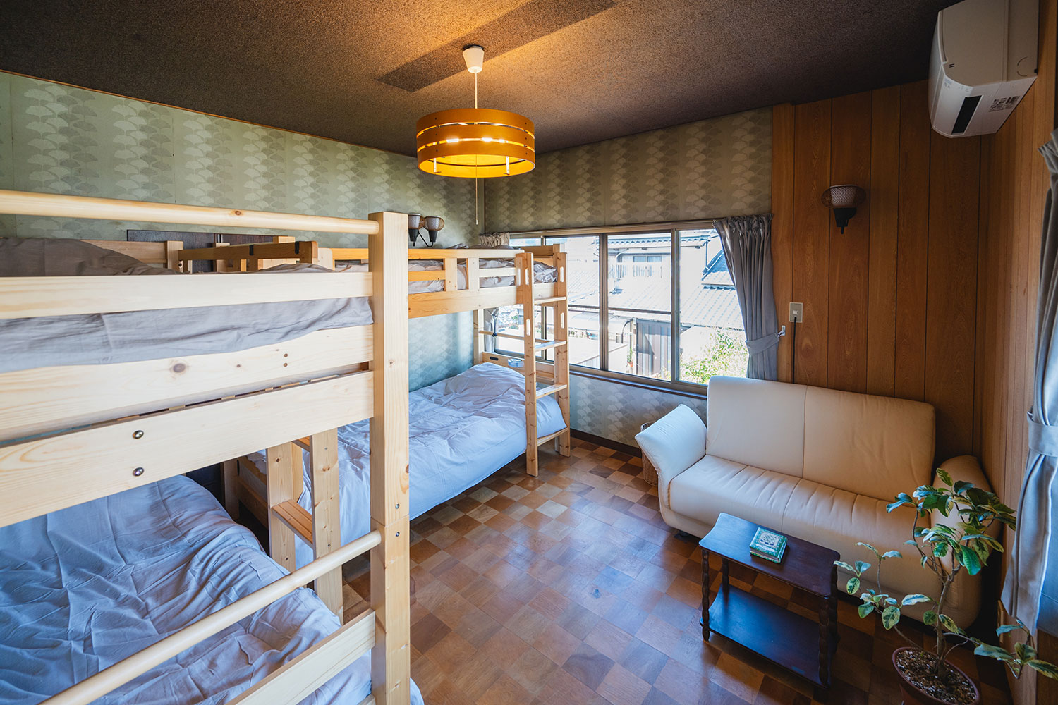 写真:2段ベッドがL字に置かれた部屋。ソファがあります。