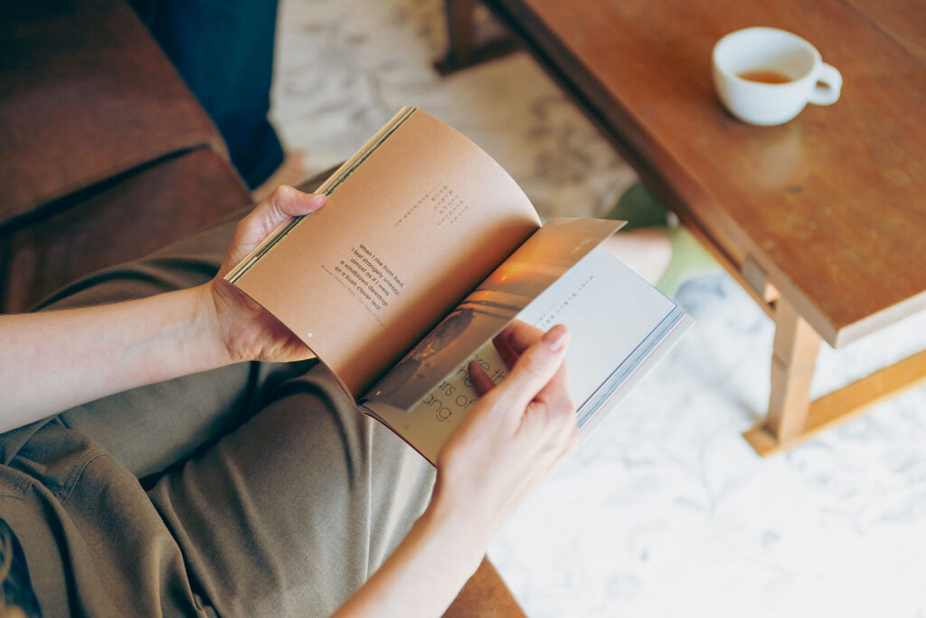 写真:ソファに座って本のページをめくる手元