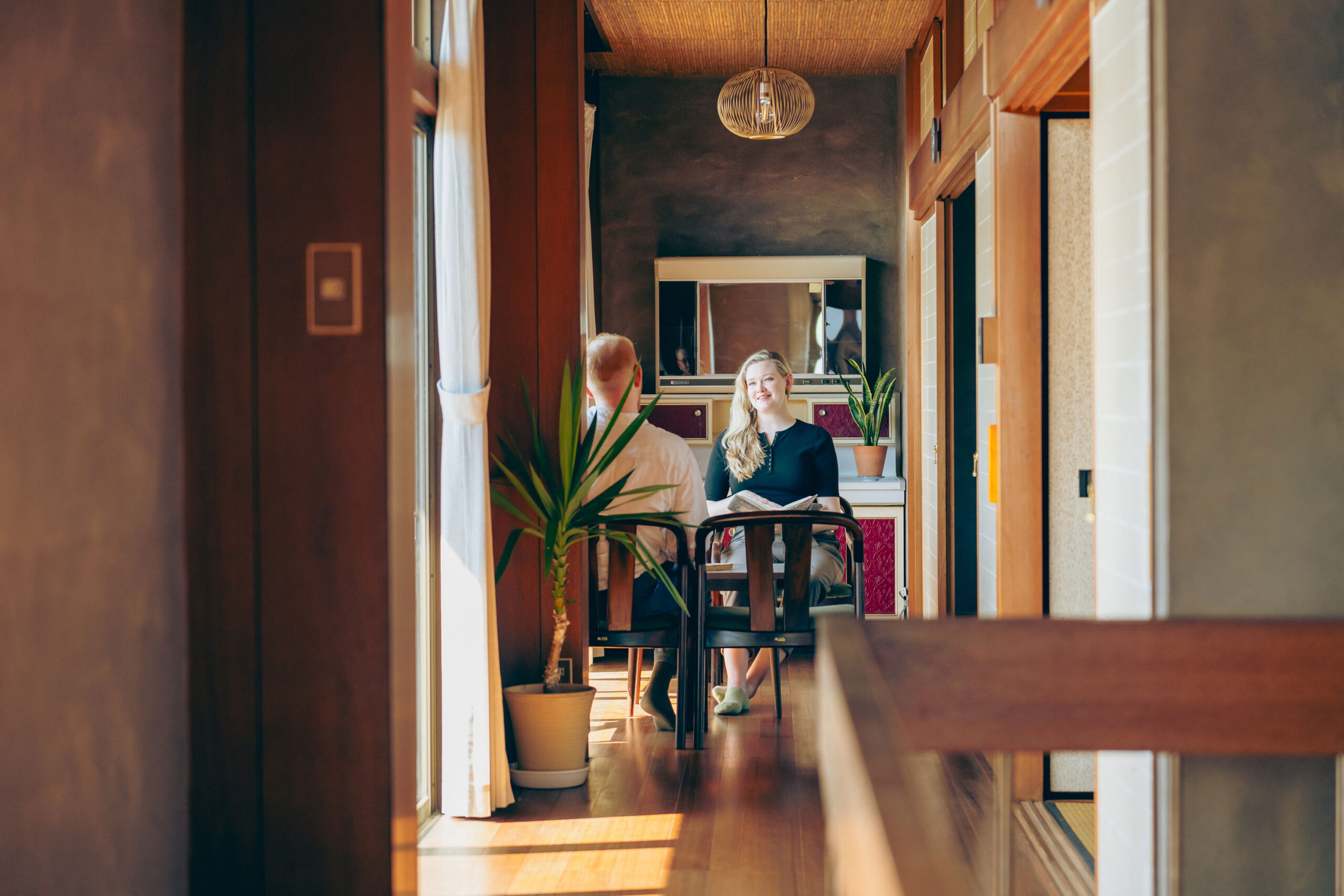 写真:縁側のテーブルで談笑する白人の男女